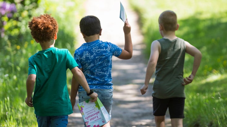 3 young boys on an Easter hunt walking through the woods